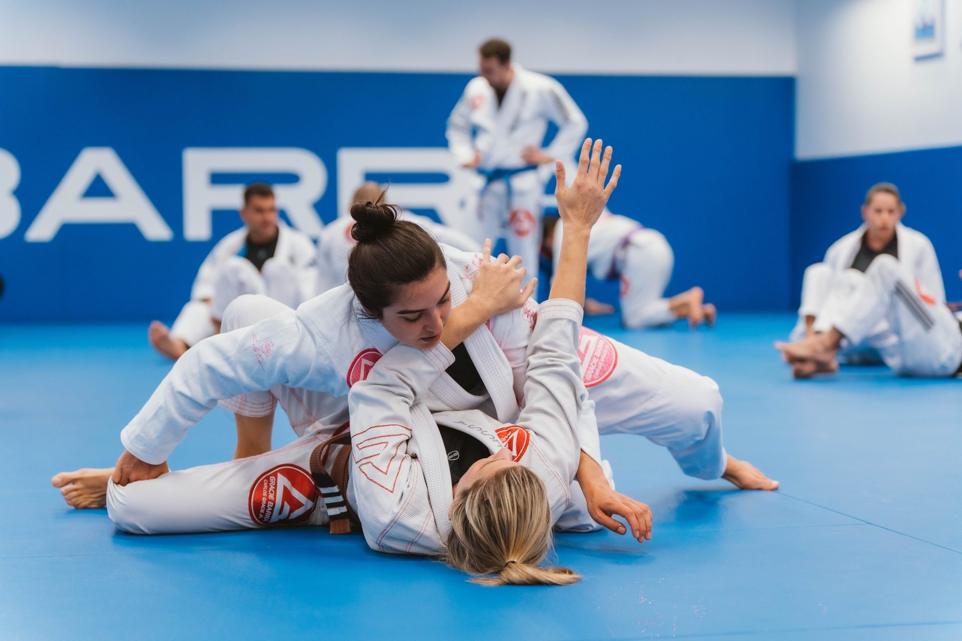 Two Gracie Barra women sparring on the mats